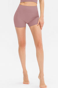 Person wearing mauve high-waisted shorts on a white background