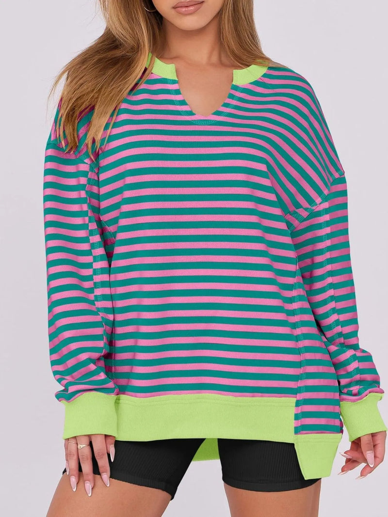 Person wearing a colorful striped long-sleeve shirt with green trim on a white background