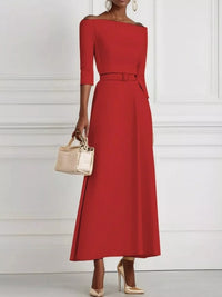 Red dress with a belt and beige handbag on a white background