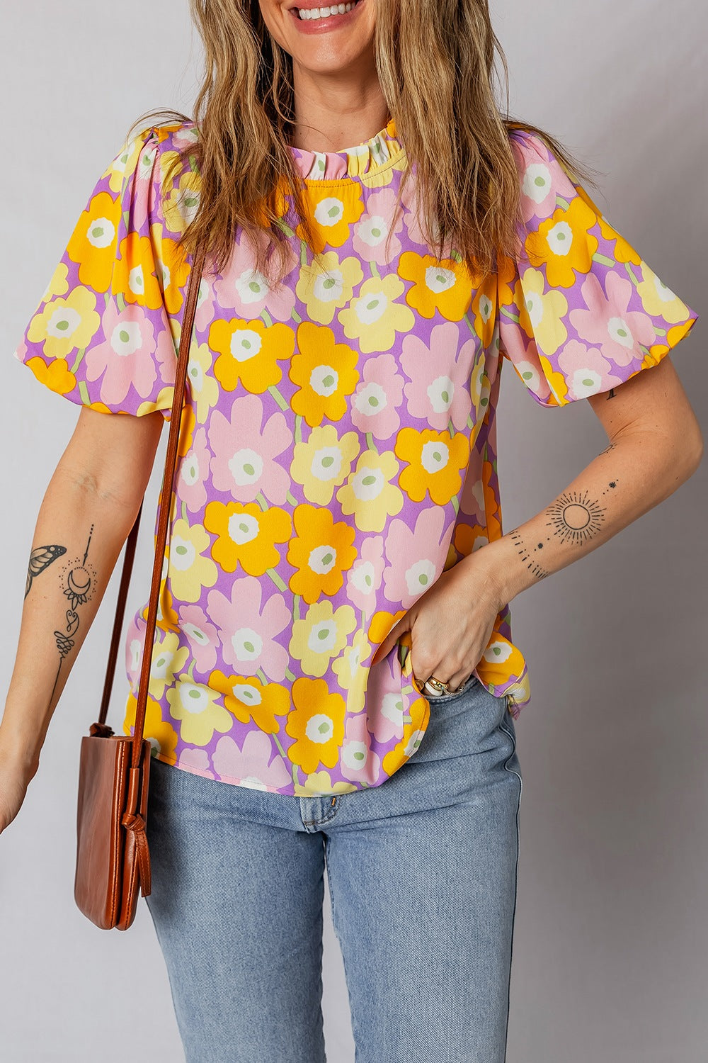 Woman wearing a colorful floral blouse with a plain background