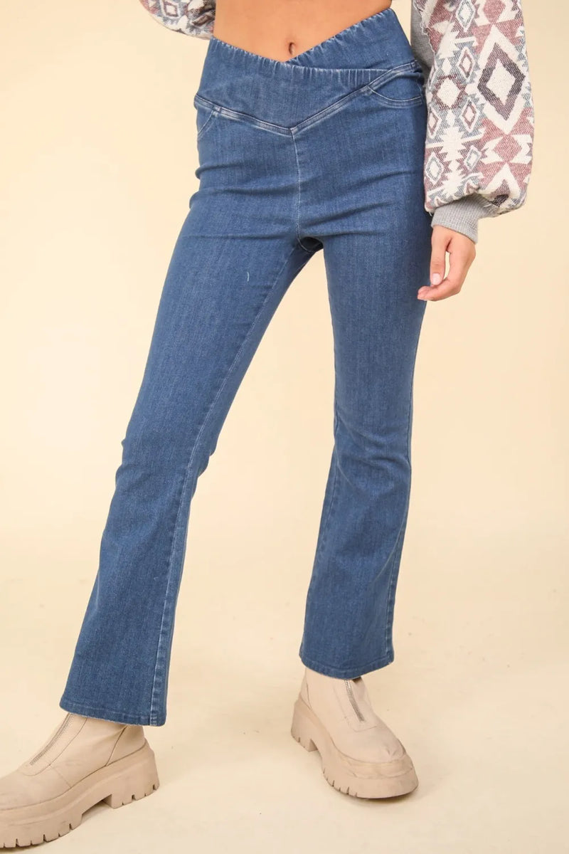 Person wearing blue jeans and beige shoes on a beige background