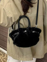 Person wearing a beige coat with a black furry handbag.