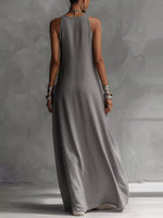 Woman wearing a long gray dress against a plain background