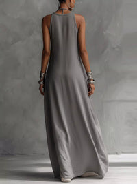 Woman wearing a long gray dress against a plain background