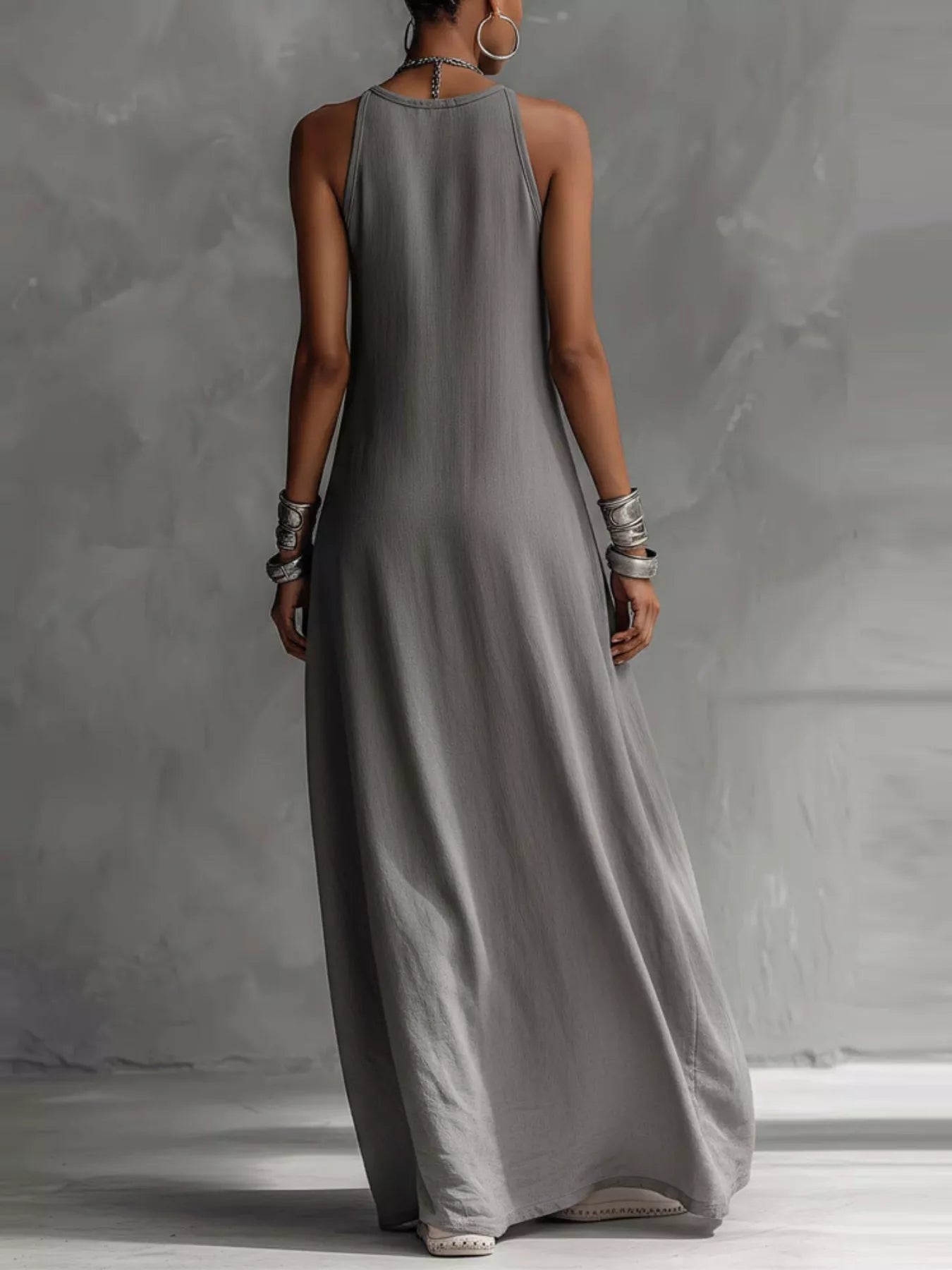 Woman wearing a long gray dress against a plain background