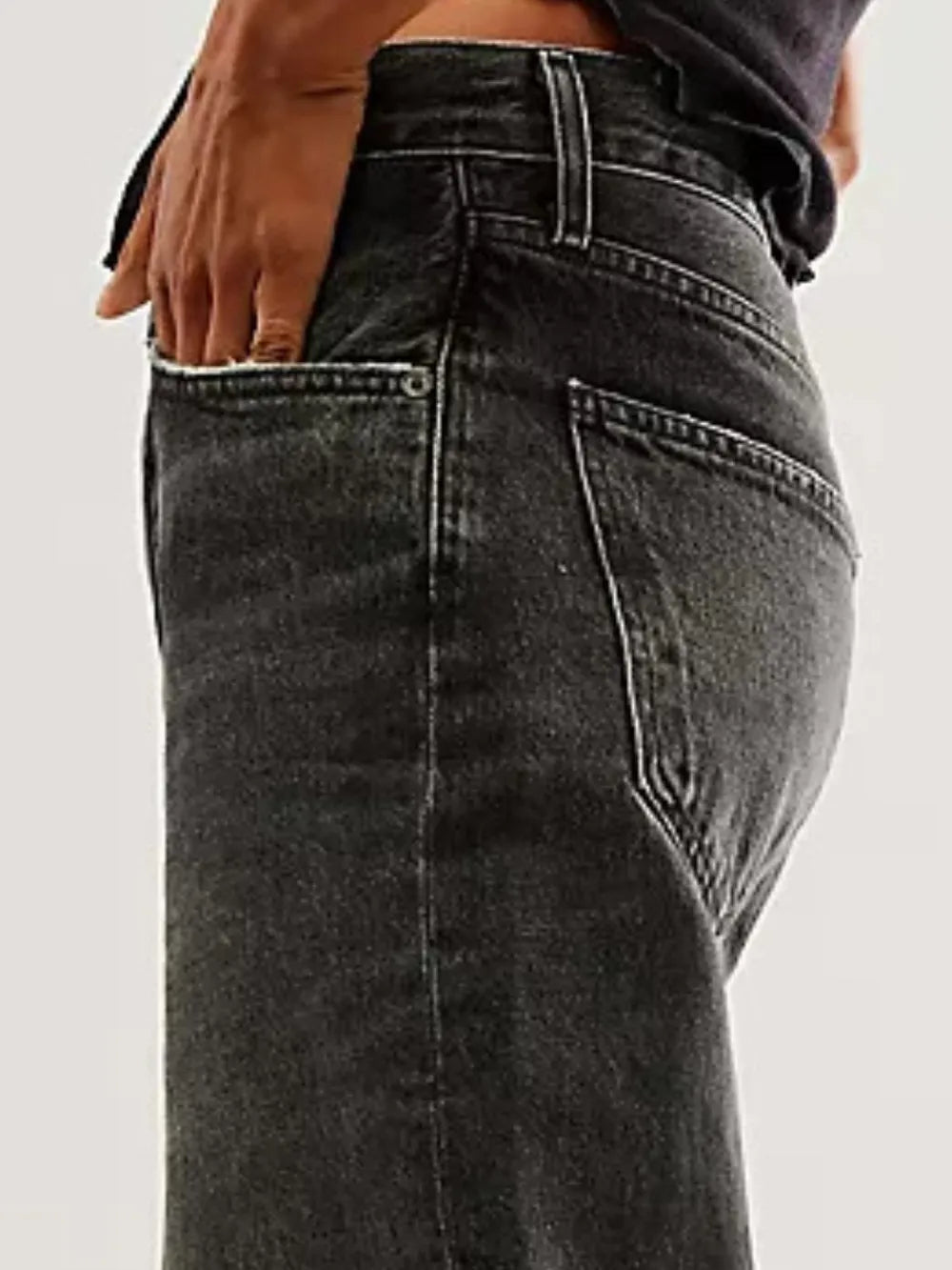 Black jeans worn by a person on a plain background