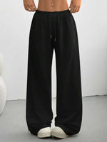 Black wide-leg pants worn by a person on a plain background