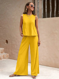 Woman wearing a yellow outfit standing in front of a beige wall.