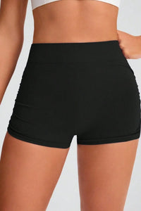 Black high-waisted shorts worn by a person on a plain background