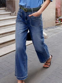 Person wearing blue jeans and a blue shirt on a street.