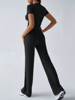 Person wearing a black outfit with wide-leg pants on a white background