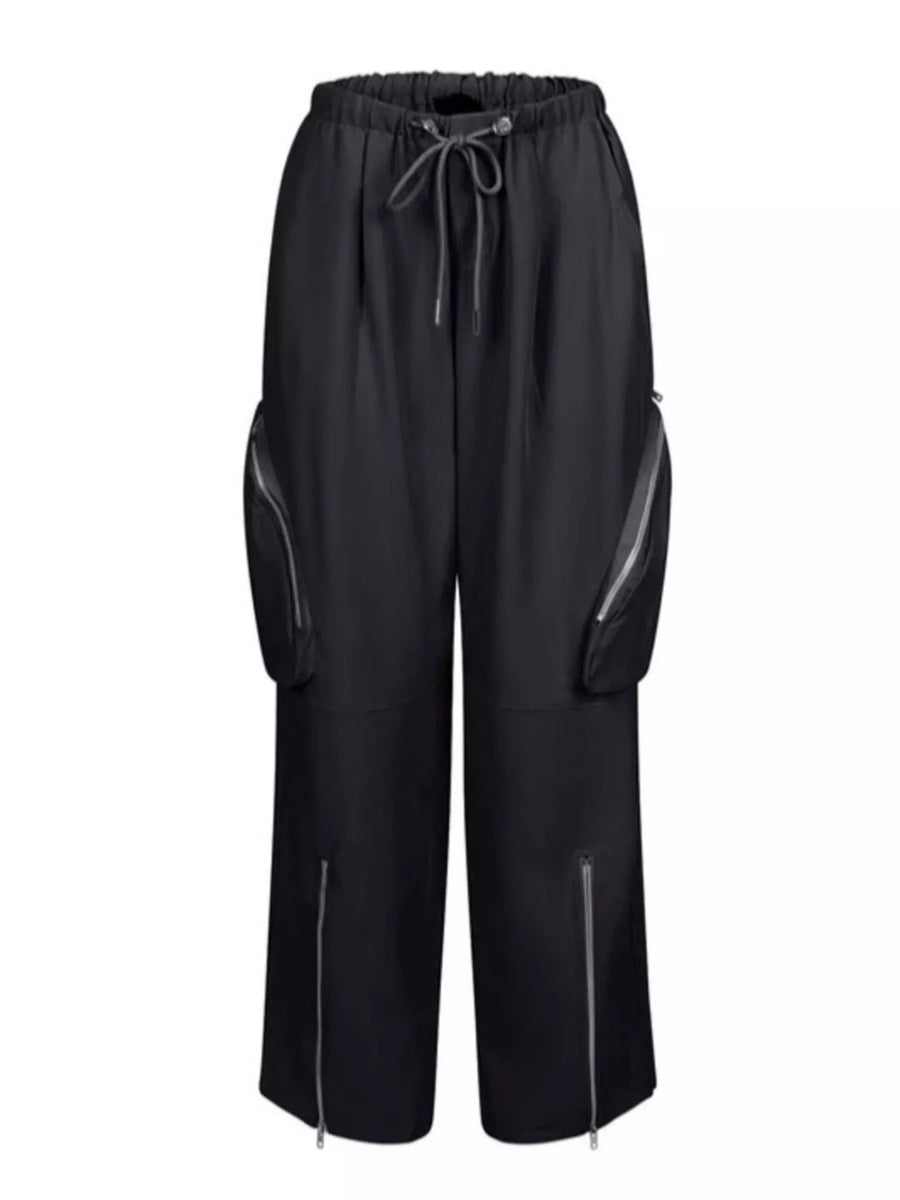 Black wide-leg cargo pants with a drawstring waist, side zip pockets, and zippered ankle details, shown against a plain white background.