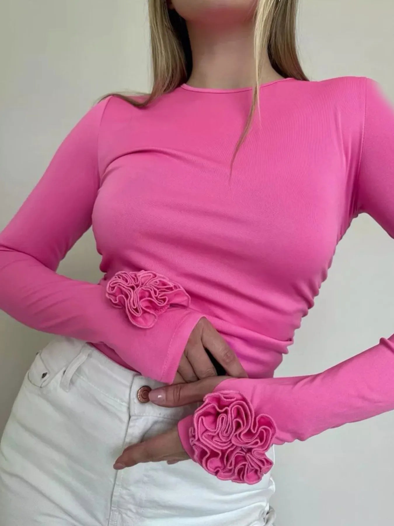 Person wearing a pink long-sleeve top and matching gloves with floral designs.