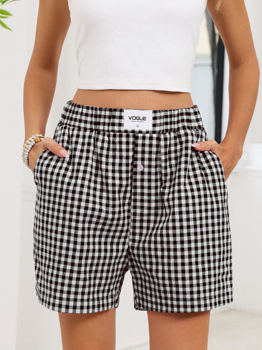 Person wearing black and white checkered shorts with a visible brand label on a light background