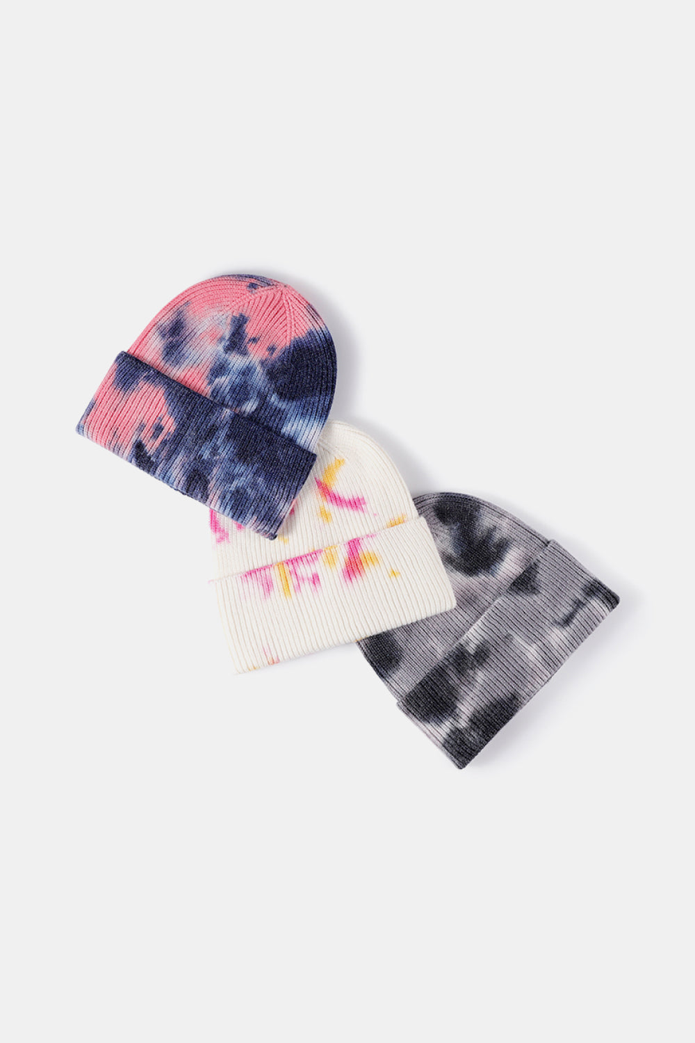 Three tie-dye beanies in different patterns on a white background