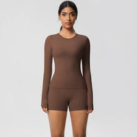 Woman wearing a brown long-sleeve top and shorts set on a light gray background