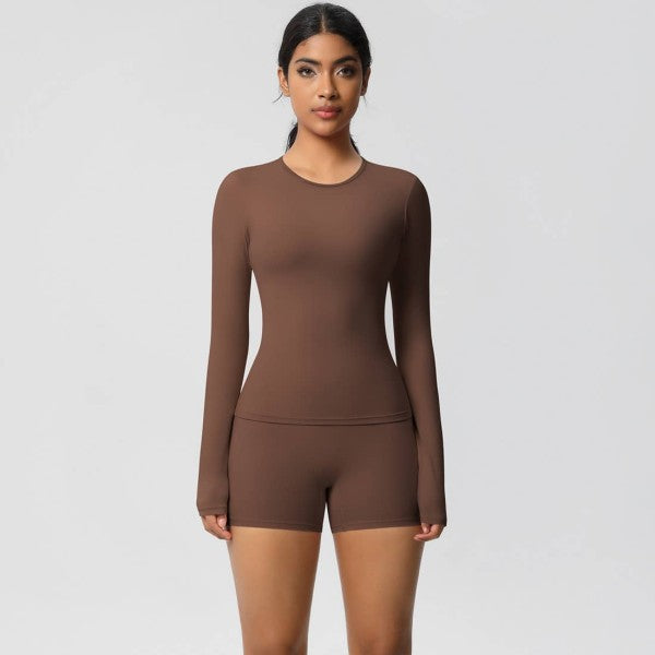 Woman wearing a brown long-sleeve top and shorts set on a light gray background