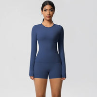 Woman wearing a blue long-sleeve top and shorts set on a light gray background