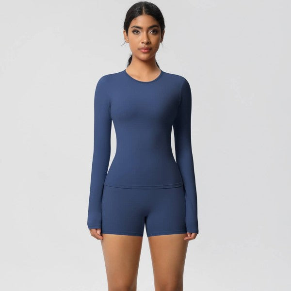 Woman wearing a blue long-sleeve top and shorts set on a light gray background