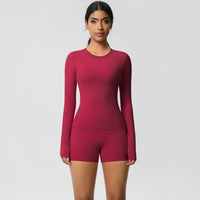 Woman wearing a pink long-sleeve top and shorts set on a light gray background