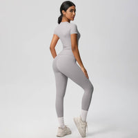 Woman wearing a gray athletic outfit on a white background