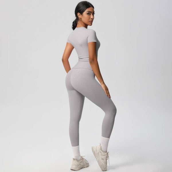 Woman wearing a gray athletic outfit on a white background