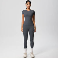 Woman wearing a gray athletic outfit on a white background