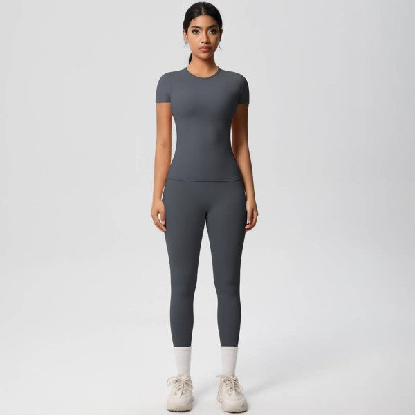 Woman wearing a gray athletic outfit on a white background