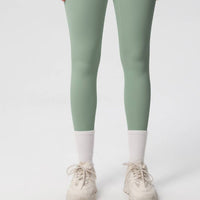 Green leggings worn by a person on a white background