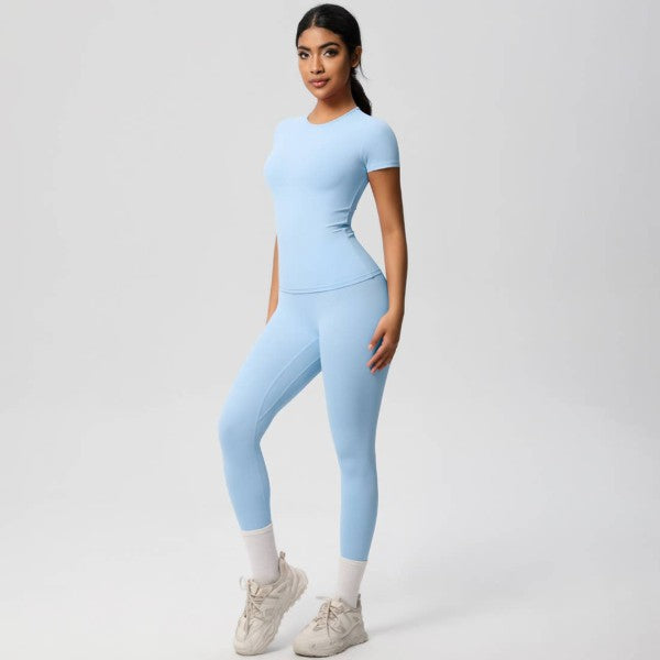 Woman wearing a light blue athletic outfit on a white background