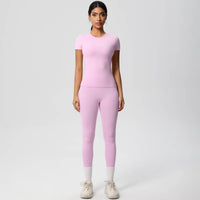 Woman wearing a pink athletic outfit on a white background