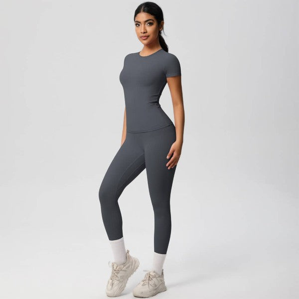 Woman wearing a gray athletic outfit on a white background