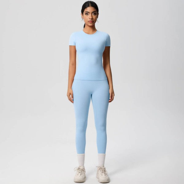 Woman wearing a light blue athletic outfit on a white background
