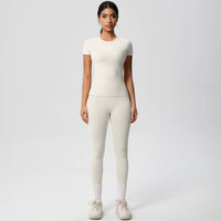 Woman wearing a white outfit on a plain background