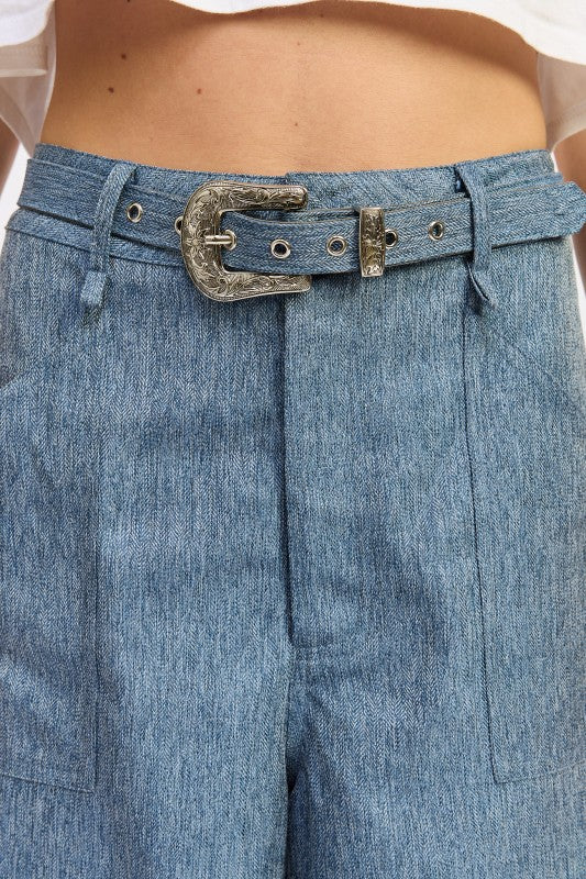 Close-up of blue denim pants with a belt and buckle.