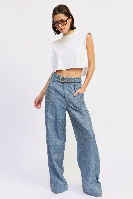 Woman wearing a white sleeveless top and blue jeans on a white background
