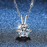 Silver necklace with a diamond pendant on a blue textured background