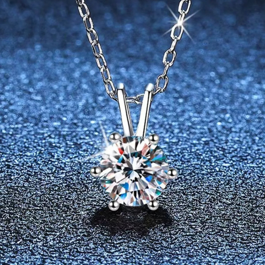 Silver necklace with a diamond pendant on a blue textured background