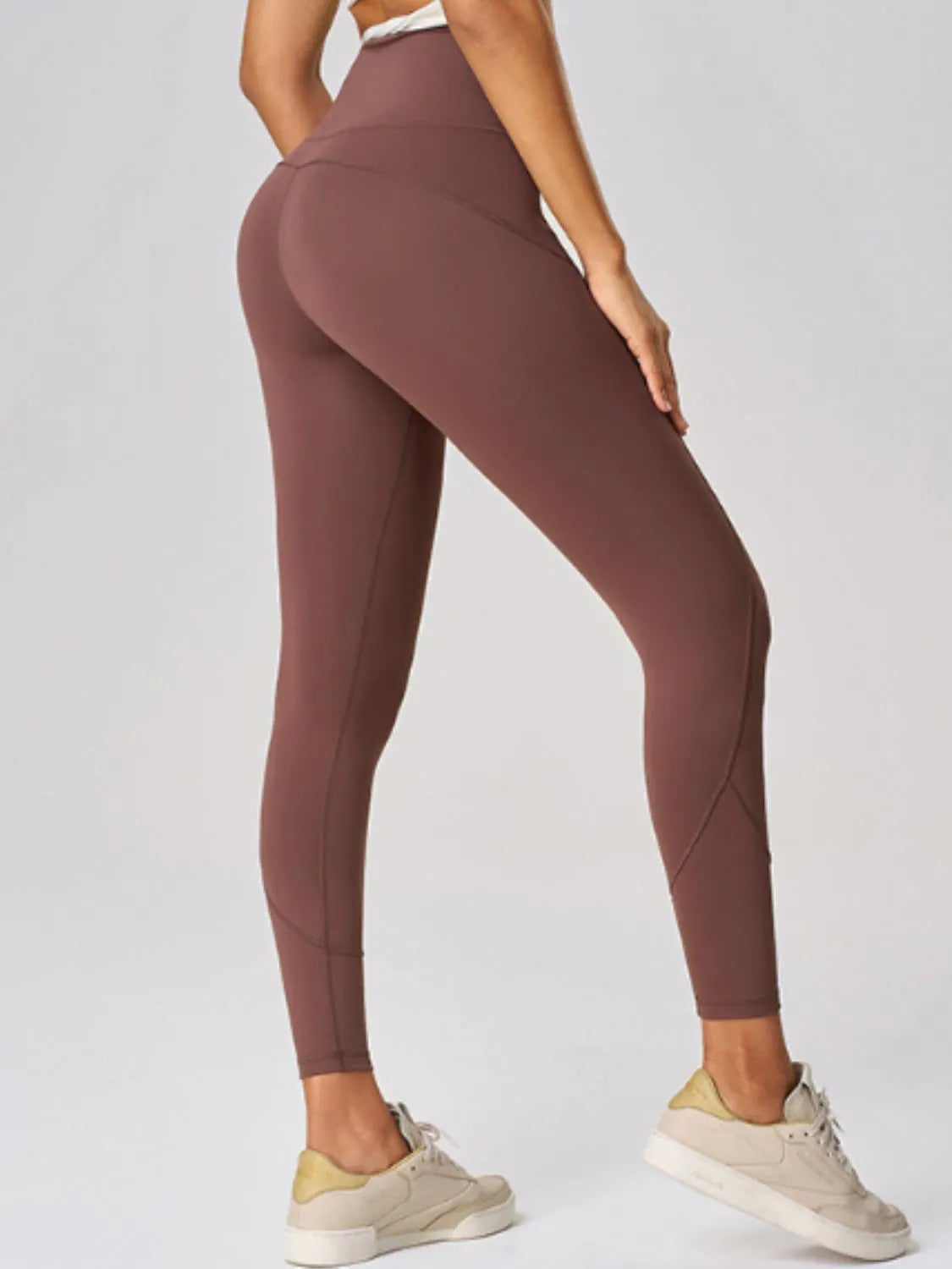 Brown leggings worn by a person on a light gray background