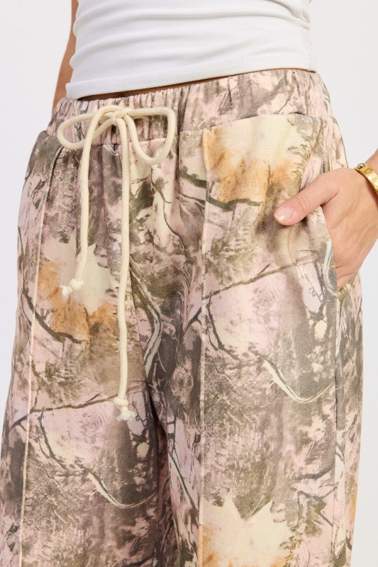 Camouflage pants with a drawstring on a plain background