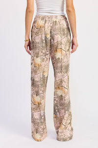 Camouflage pants worn by a person on a white background