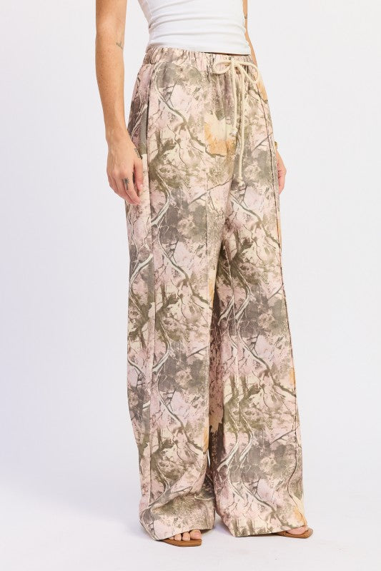 Camouflage-patterned pants worn by a person on a white background