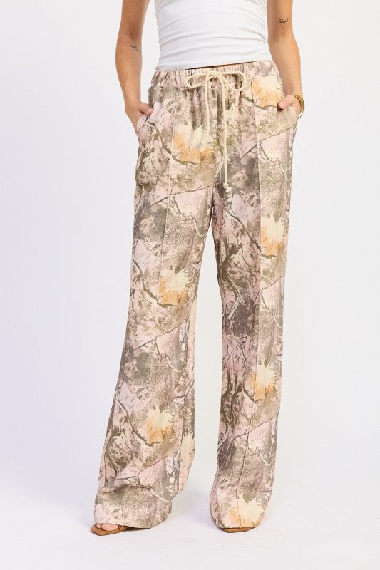 Camouflage-patterned pants worn by a person on a white background