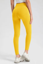 Yellow leggings worn by a person on a white background