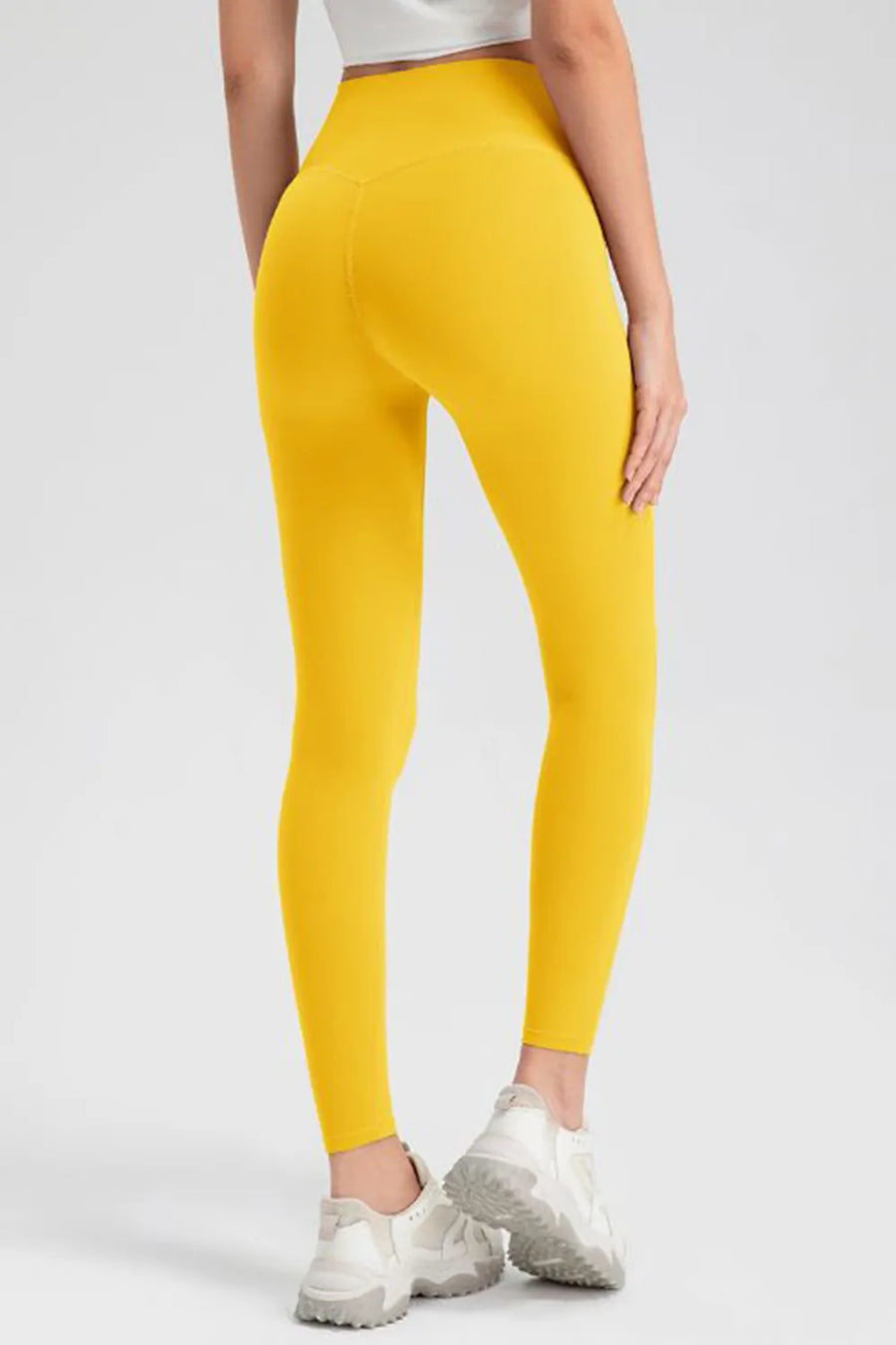 Yellow leggings worn by a person on a white background