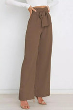 Brown wide-leg pants with a tie waist worn by a person on a white background