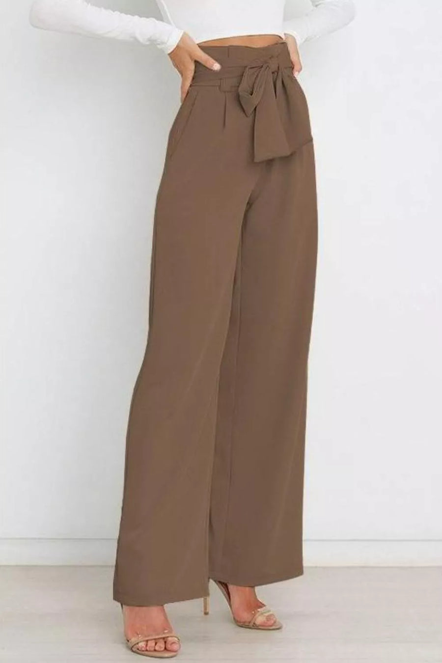 Brown wide-leg pants with a tie waist worn by a person on a white background