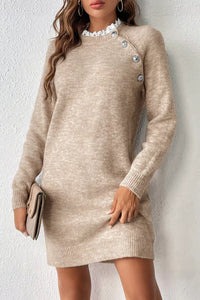 Beige sweater dress worn by a person against a white background