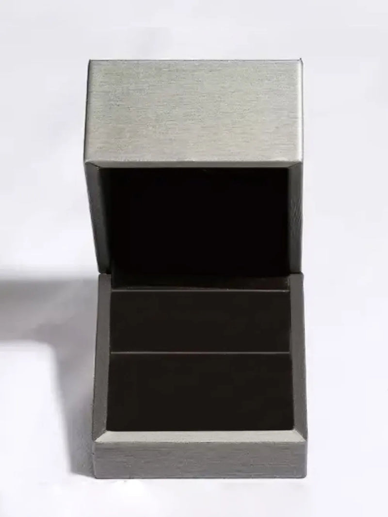Modern side table with metallic top and black base on a white background