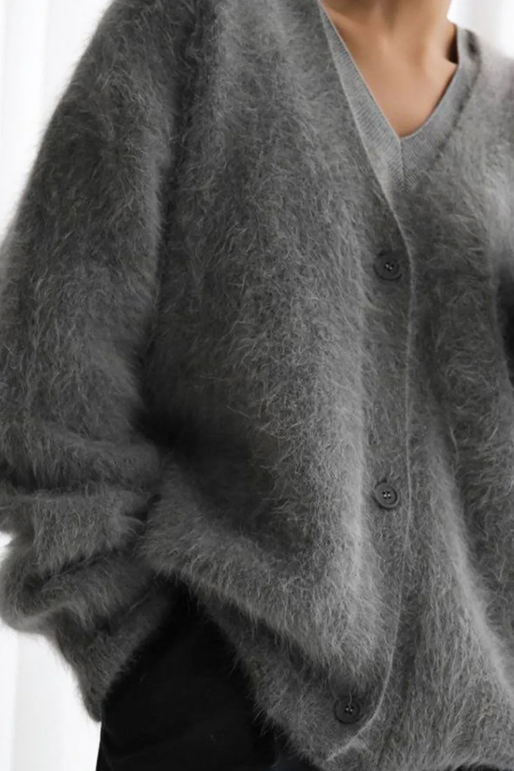 Gray cardigan worn by a person on a white background